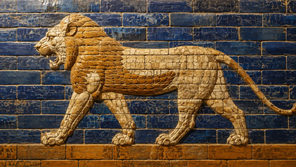 Ochre lion relief formed from glazed bricks against a cobalt-blue Babylonian-style wall